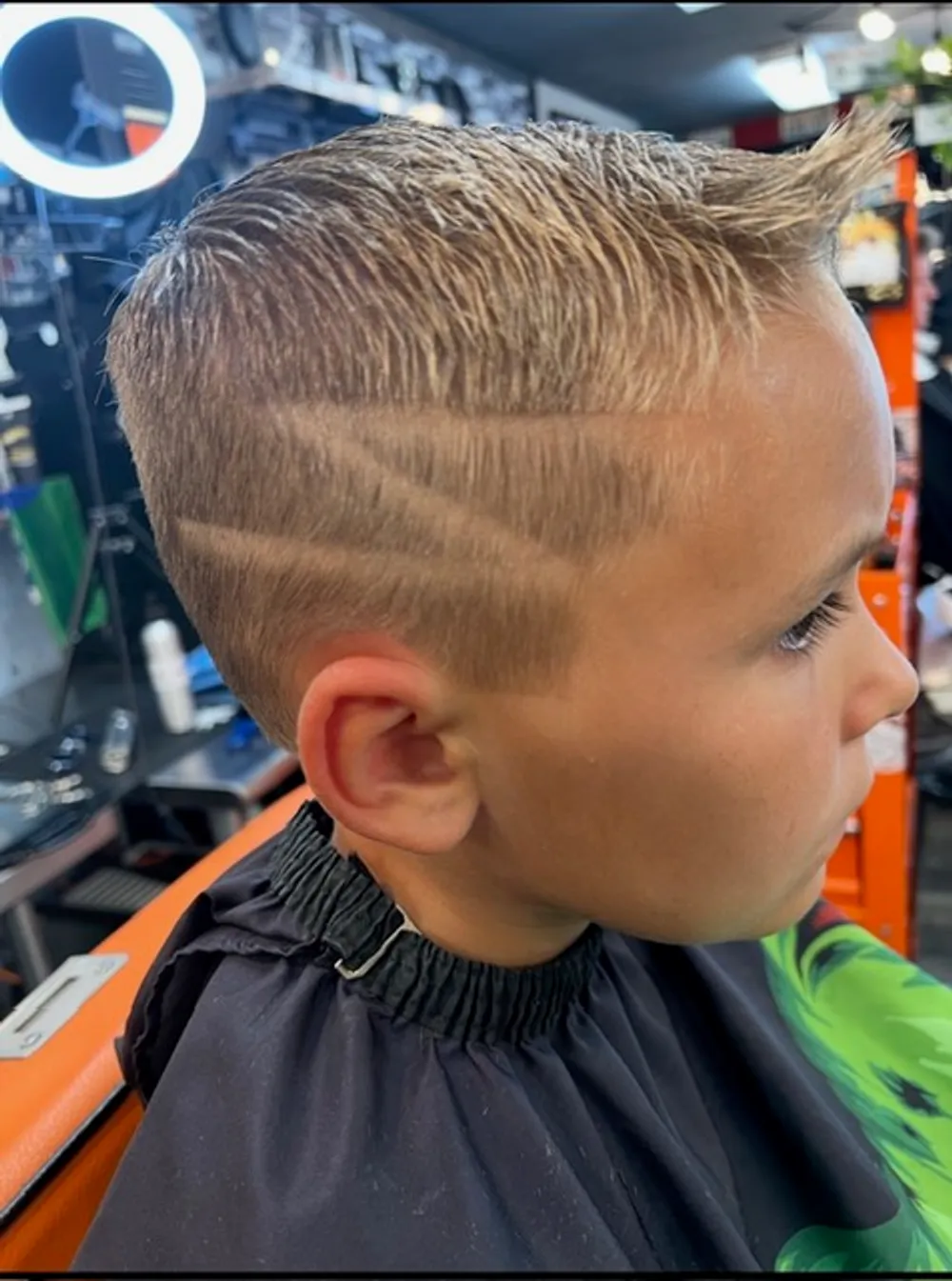 A young client's finished cut with a razored side design at Barber Shack.
