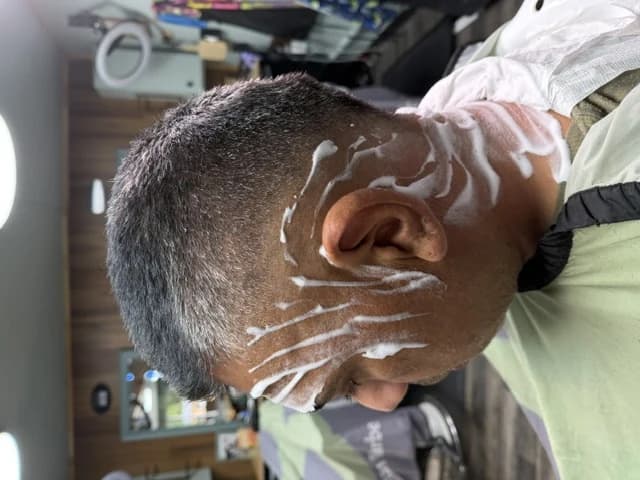 A client lathered up for a straight-razor shave at Barber Shack.